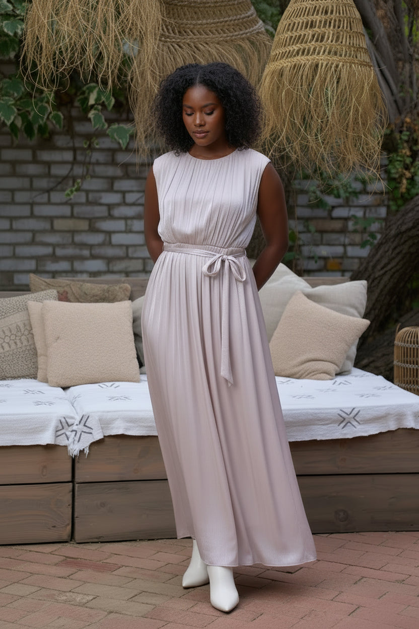 Woman in a flowing dress standing outdoors with a rustic background